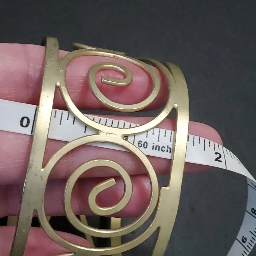 Gold tone swirly bangle cuff bracelet